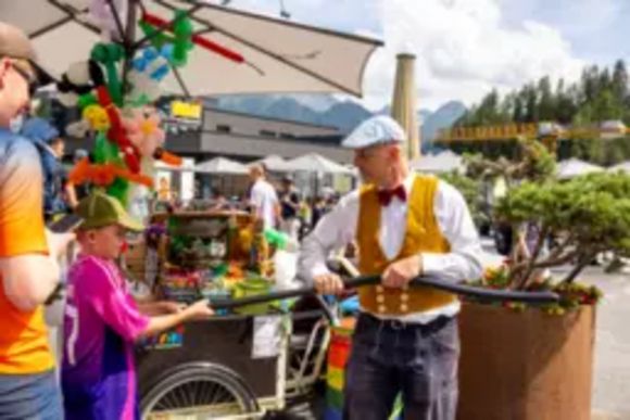 Luftballonverkäufer auf Volksfest mit Tracht und mobilen Stand